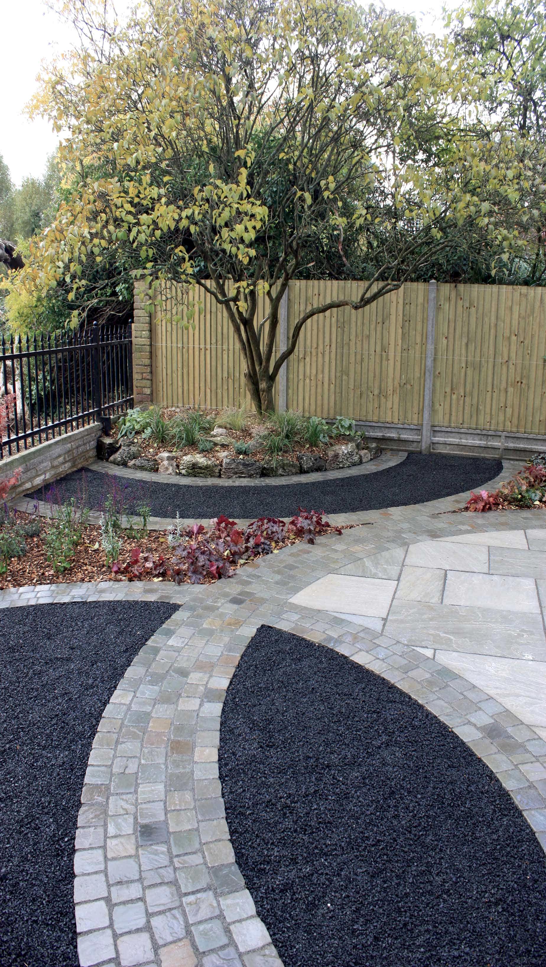 basalt paving with featherboard fencing