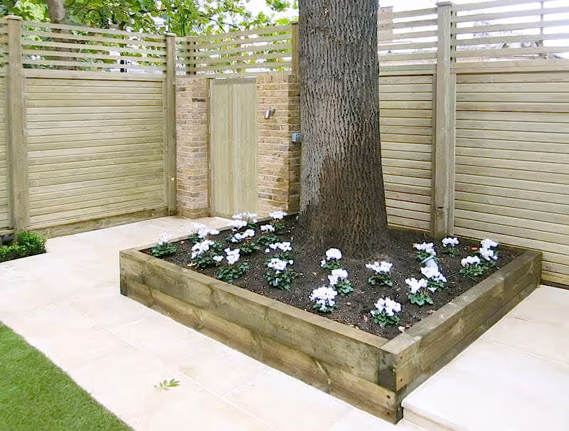 New panels and garden gate with raised bed around tree