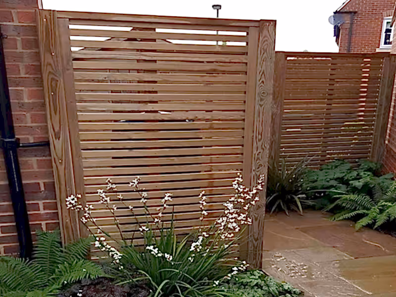 slatted fence hides bins