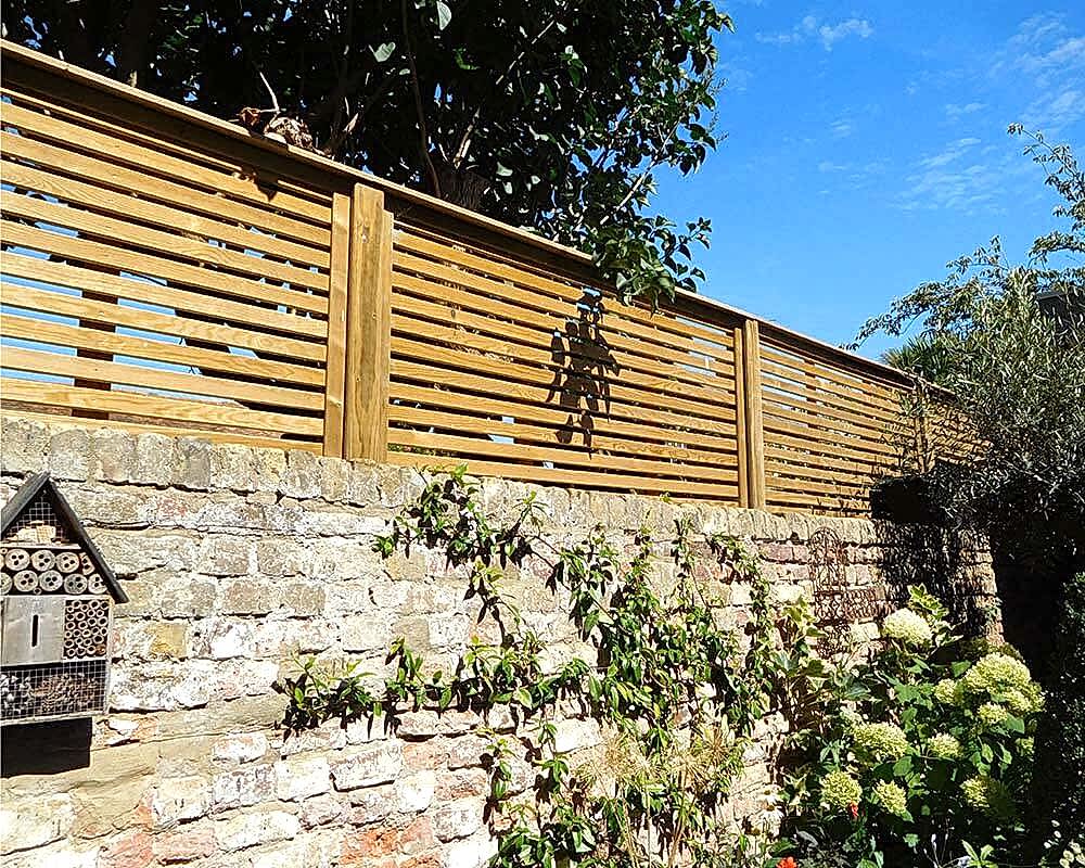 venetian fencing installed on top of wall