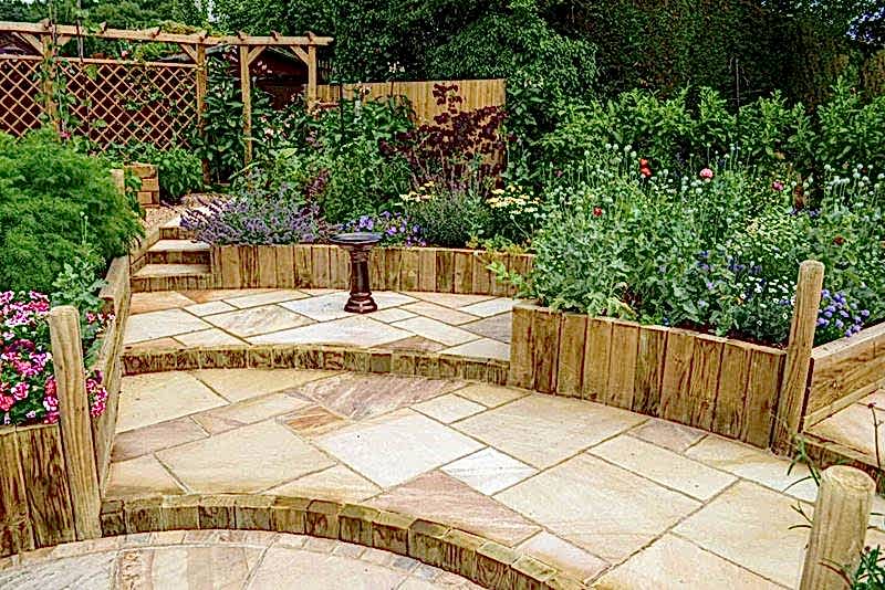 garden with steps from landscape timbers and single wooden pergola